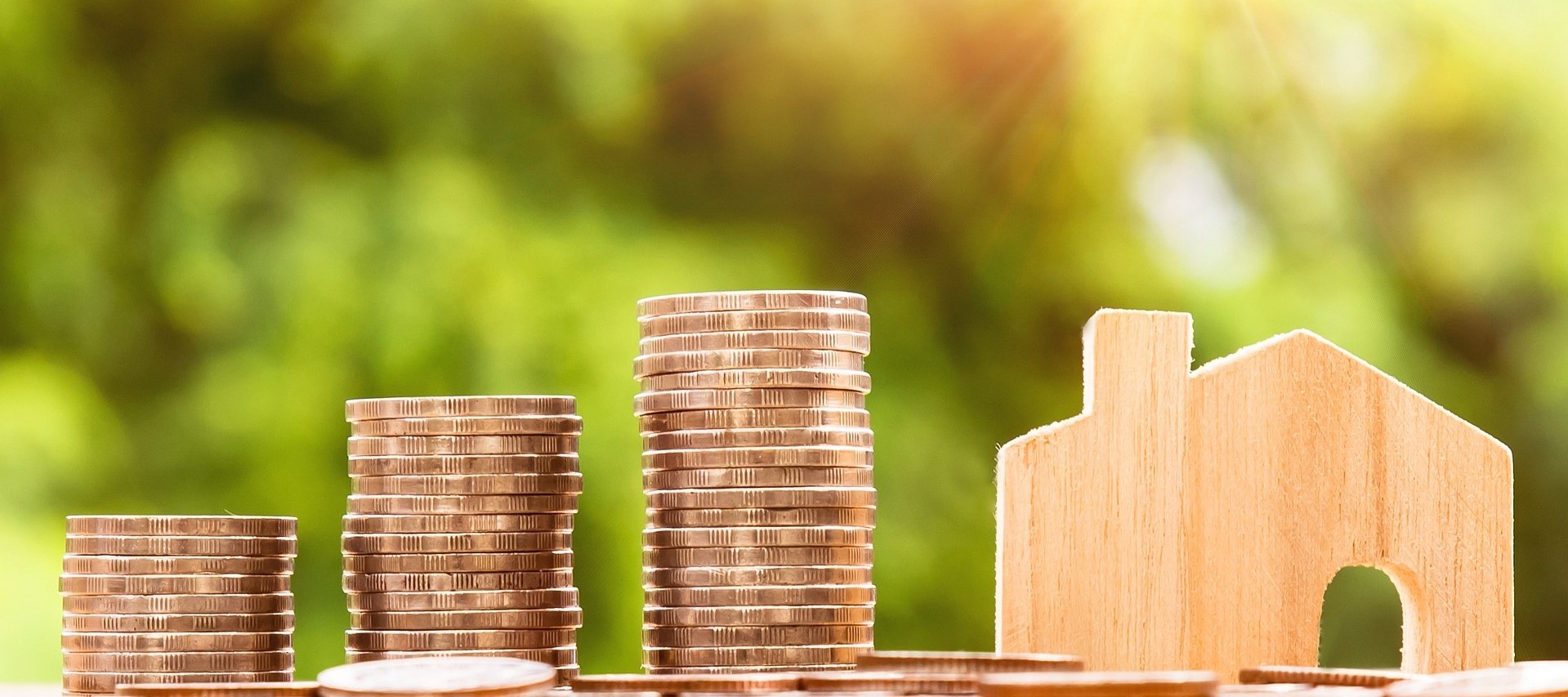 stack of gold coins and wooden house